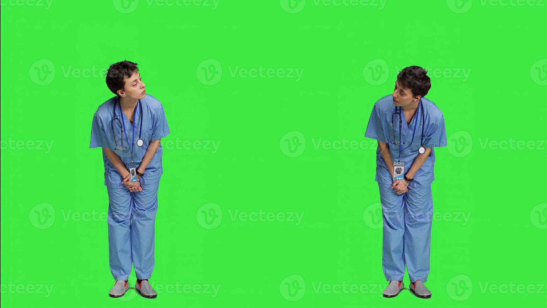 Medical assistant being impatient against greenscreen backdrop, looking around and waiting for patients at consultations. Nurse with health expertise feeling frustrated while she waits. Camera A. photo