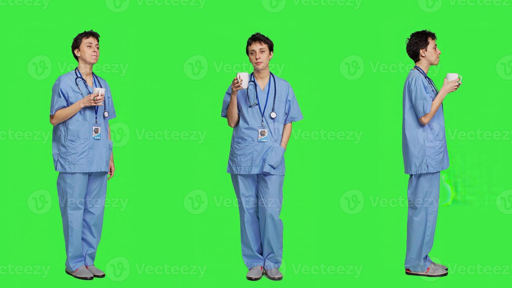 Medical assistant drinking cup of coffee before starting exam appointments in the morning, enjoying caffeine refreshment against greenscreen backdrop. Nurse drinks beverage. Camera A. photo