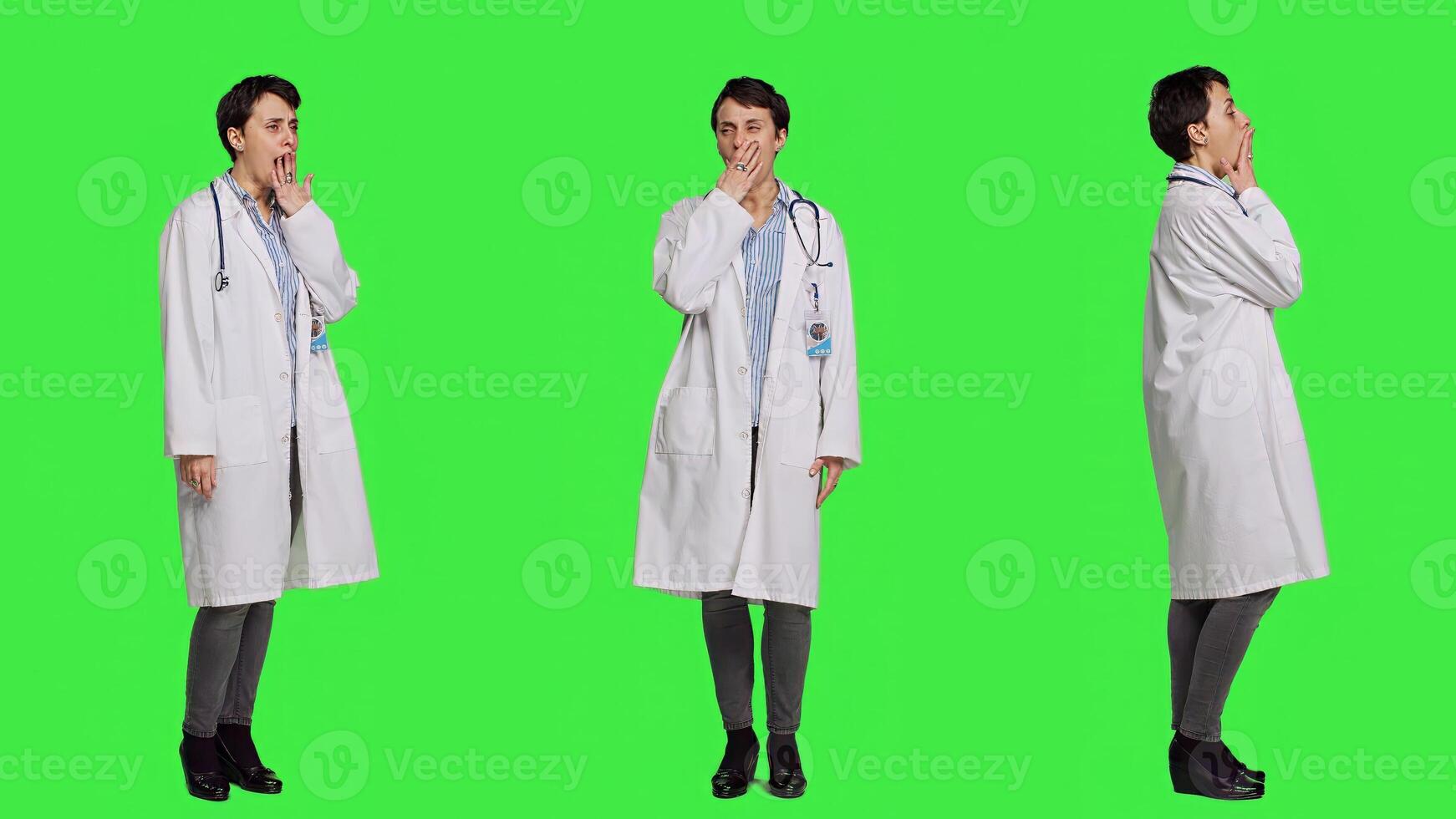 Tired general practitioner yawning and feeling overworked after night shift at hospital, exhaustion and work pressure. Medic being tired and experiencing burnout against greenscreen. Camera A. photo