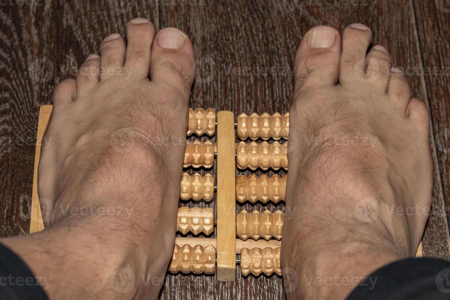 Shot of the man using feet massager to improve flatfoot. Healthcare photo