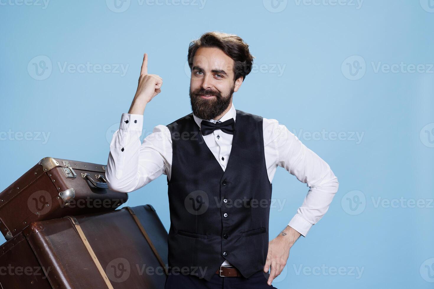 Doorkeeper coming up with new idea, finding solution in studio with background. Hotel concierge employee in suit being genius and thinking about answer to solve problem on camera. photo