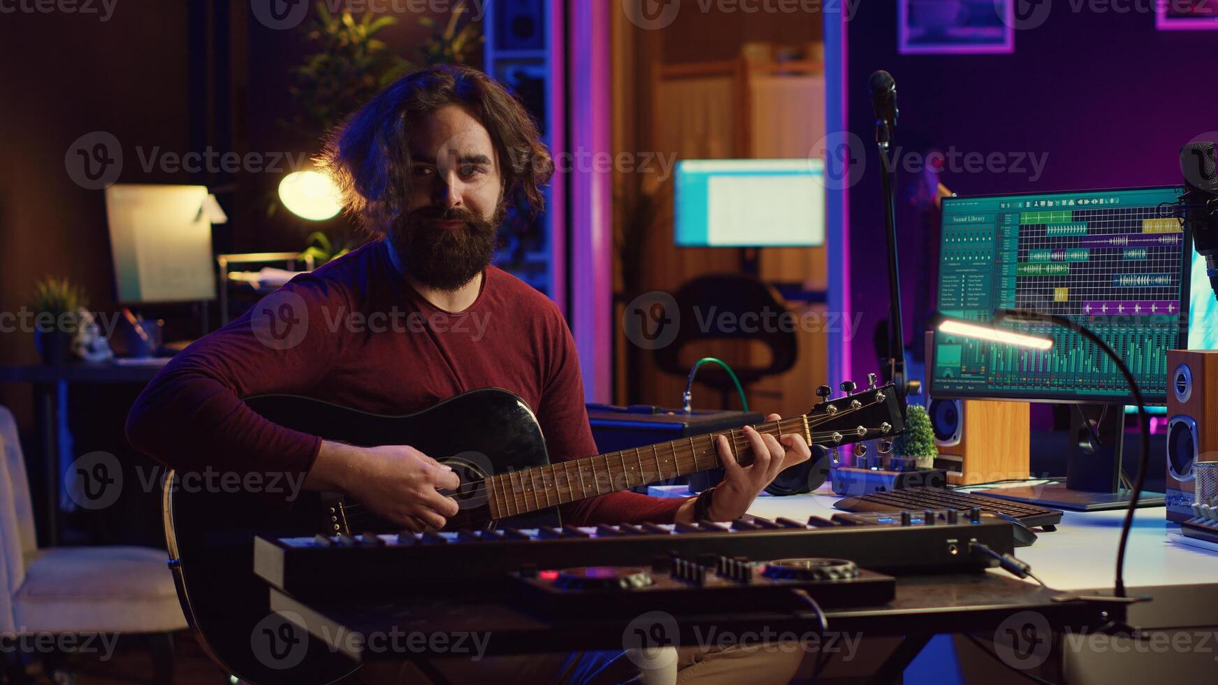Musician plays acoustic guitar and records melody to compose new song and tunes. Computer screen showing DAW software interface with soundtracks, sound engineer in music production. Camera A. photo