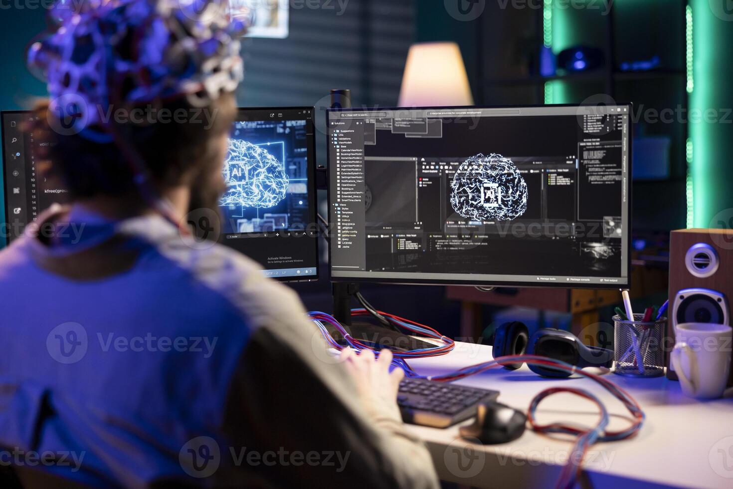 Software technician using EEG headset gear translating thoughts into PC commands using brainwave signals. IT specialist controlling computer functions using mind, helped by scifi technology photo