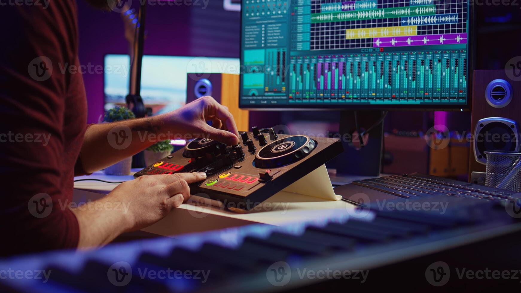 Artist editing sounds on mixing console in home studio, operating professional audio equipment to adjust volume levels on track recordings. Musician works with daw software an pre amp knobs, Camera B. photo