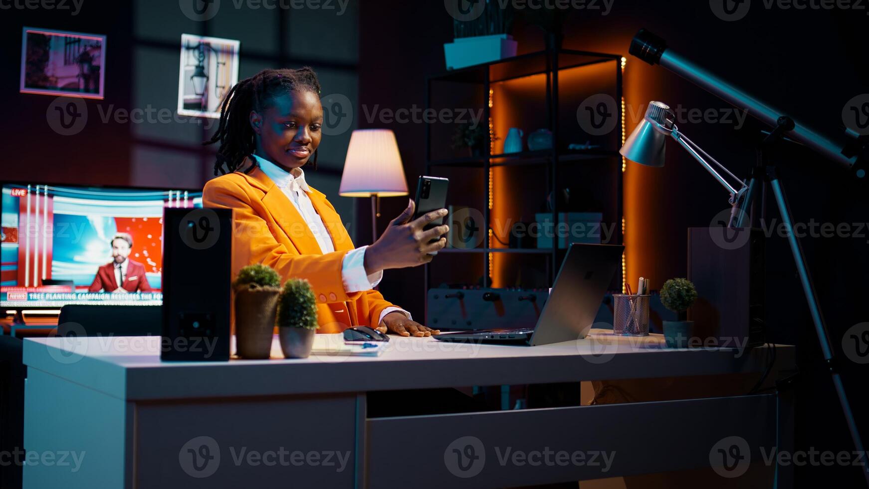 Young woman waving at phone call with tutor and classmates, asking for guidance in creating presentations and slideshows. African american student attending online class conference. Camera B. photo