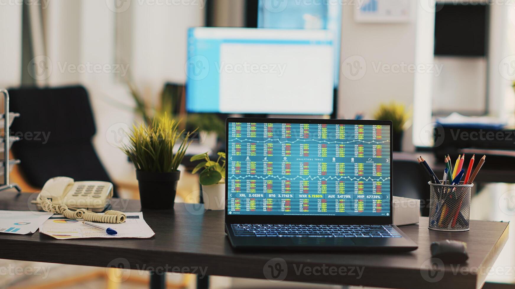 Desk in empty office with laptop showing stock exchange data collected to develop trading strategies. Forex analytics on notebook screen in company workplace showing trading platform photo