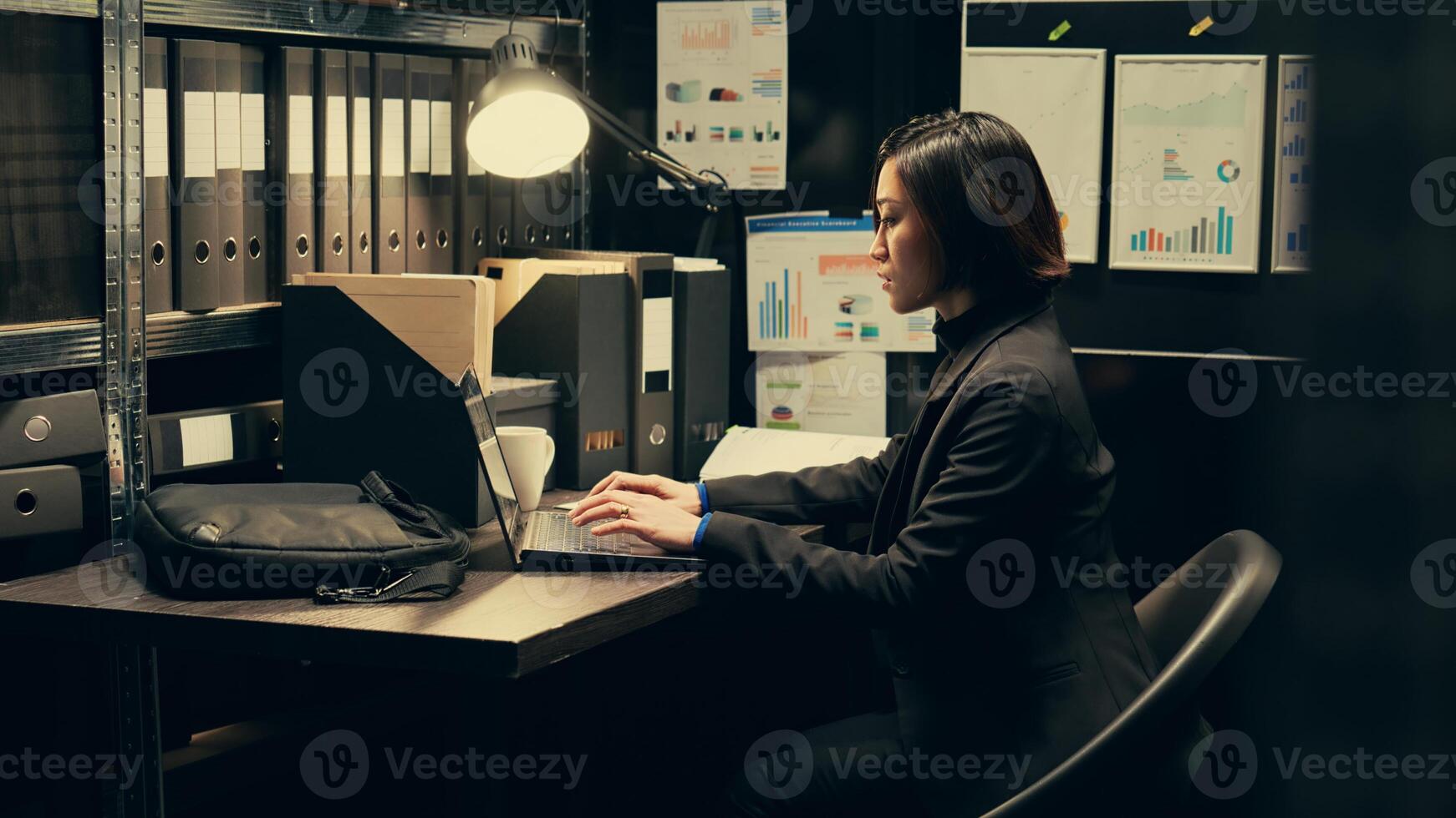 Detective uses forensic techniques to examine evidence stored in the archive, browsing through old classified documents to uncover clues. Private inspector studying classified information. Camera B. photo