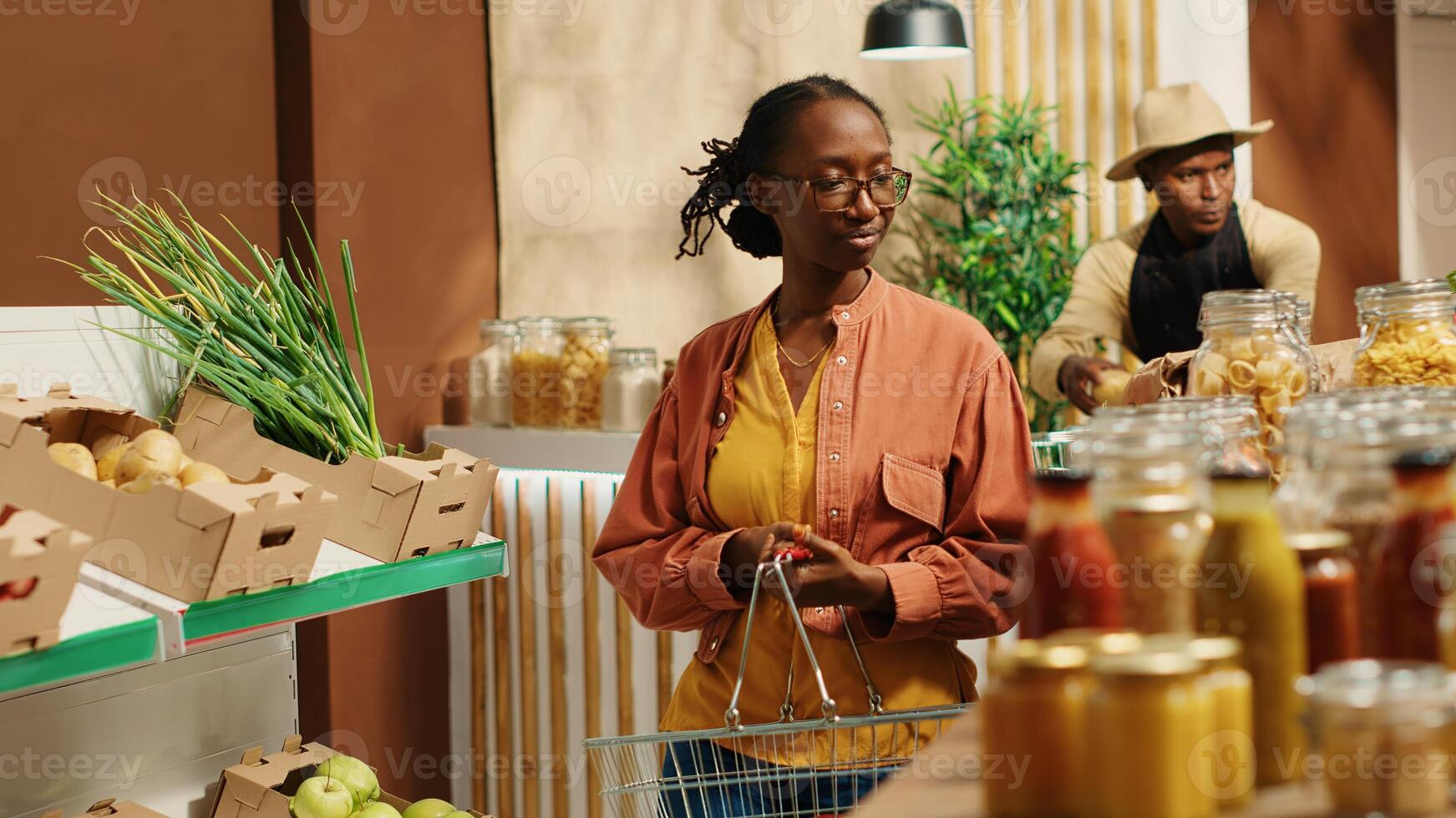 Regular customer searching for eco friendly food alternatives, looking at homemade ethically sourced bulk items at local supermarket. African american vegan woman going grocery shopping. Camera 1. photo