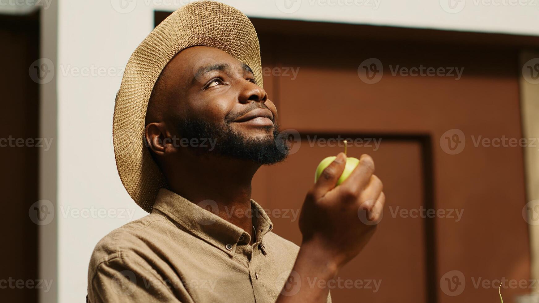 African american man smelling locally grown apples at supermarket, supporting nonpolluting small business by buying bio food. Client choosing fruits from crates, enjoying natural aroma. Camera 1. photo