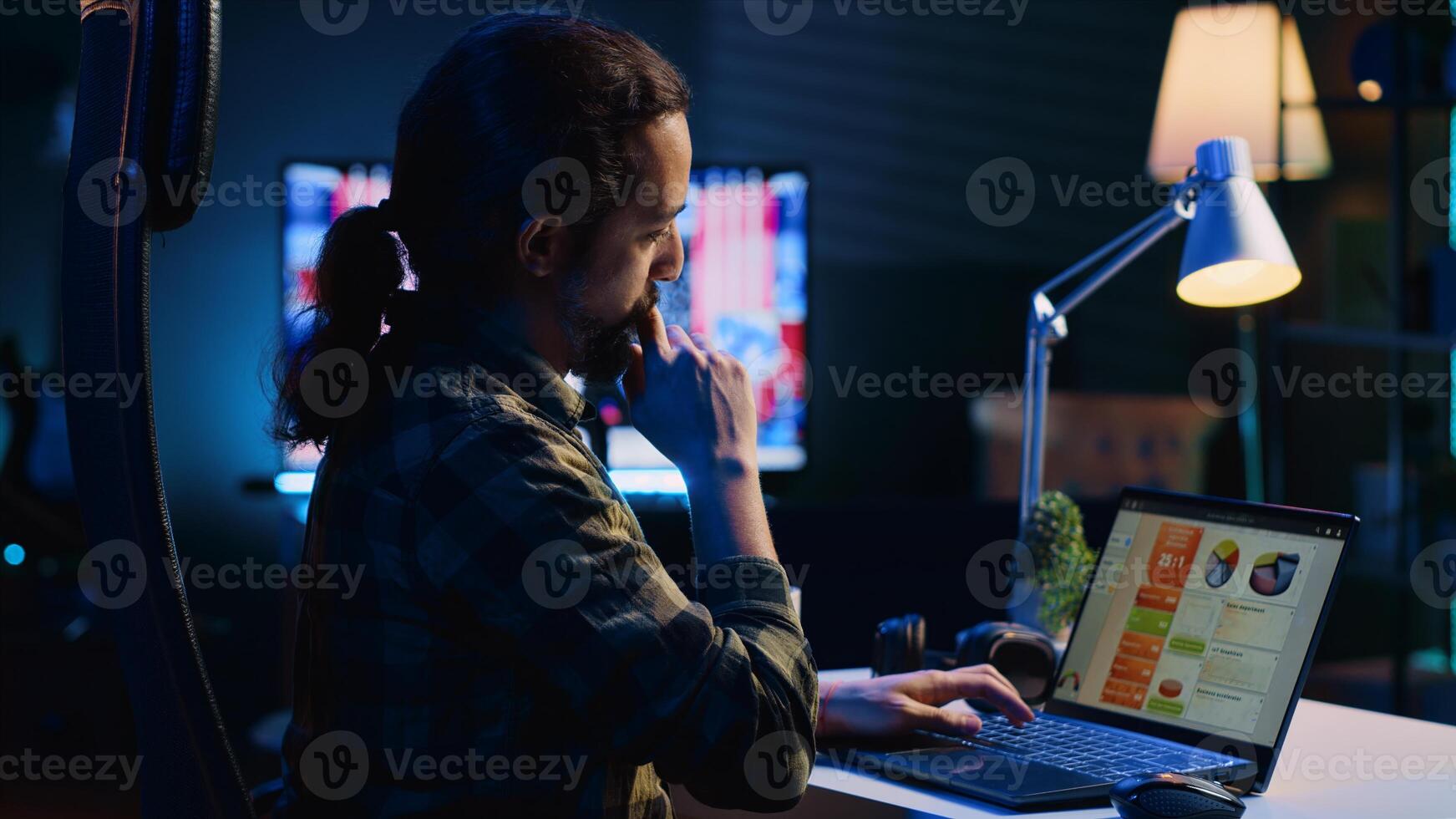 Self employed man working in personal office, checking statistical data financial graphs on laptop screen. Remote employee in living room comparing business graphic economic figures, camera A photo