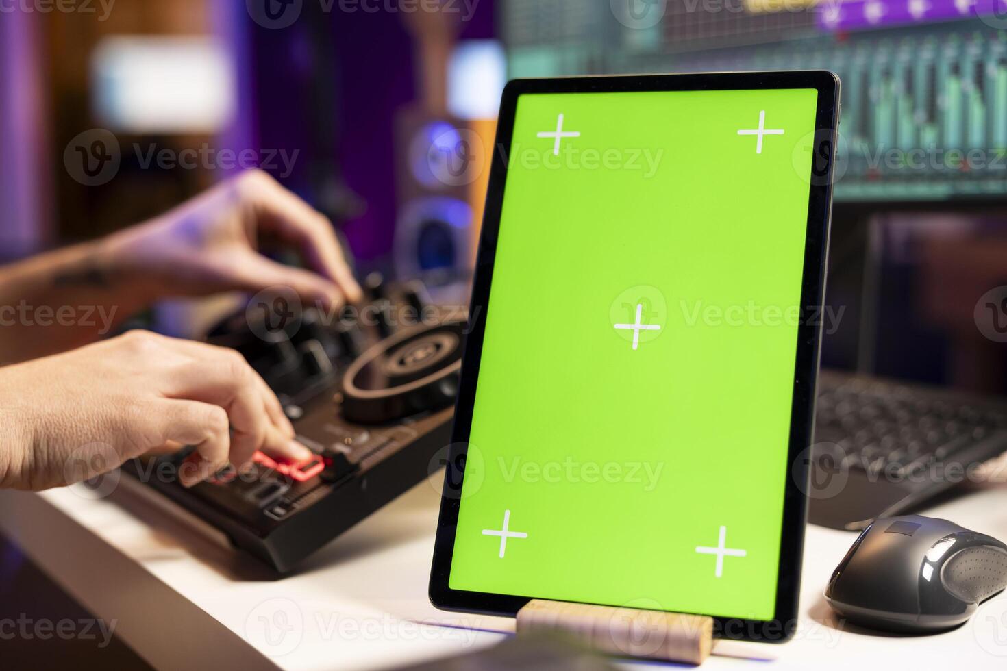 Musician mixing and mastering soundtracks on console, greenscreen display on tablet, editing tunes in home studio. Young composer songwriter adjusting volume levels on tunes, daw software. photo