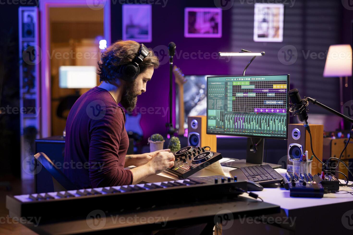 Young artist mixing and mastering tunes on professional console, adding sound effects in editing session before launching new music. Audio producer songwriter creating tunes in home studio. photo