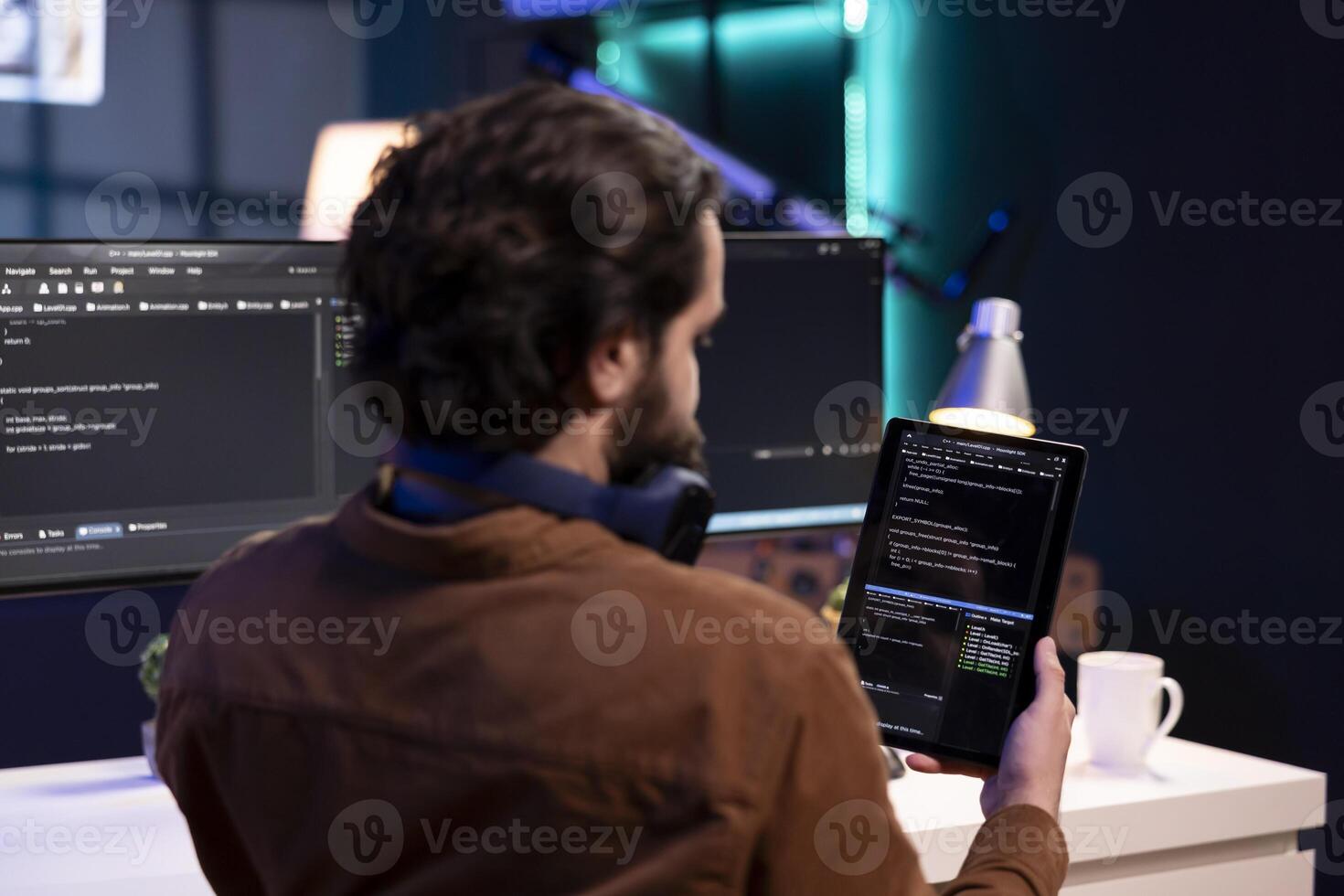 Man doing software quality assurance using tablet, reading source code before implementing it. Programmer inspecting coding on portable device, looking to fix potential bugs photo