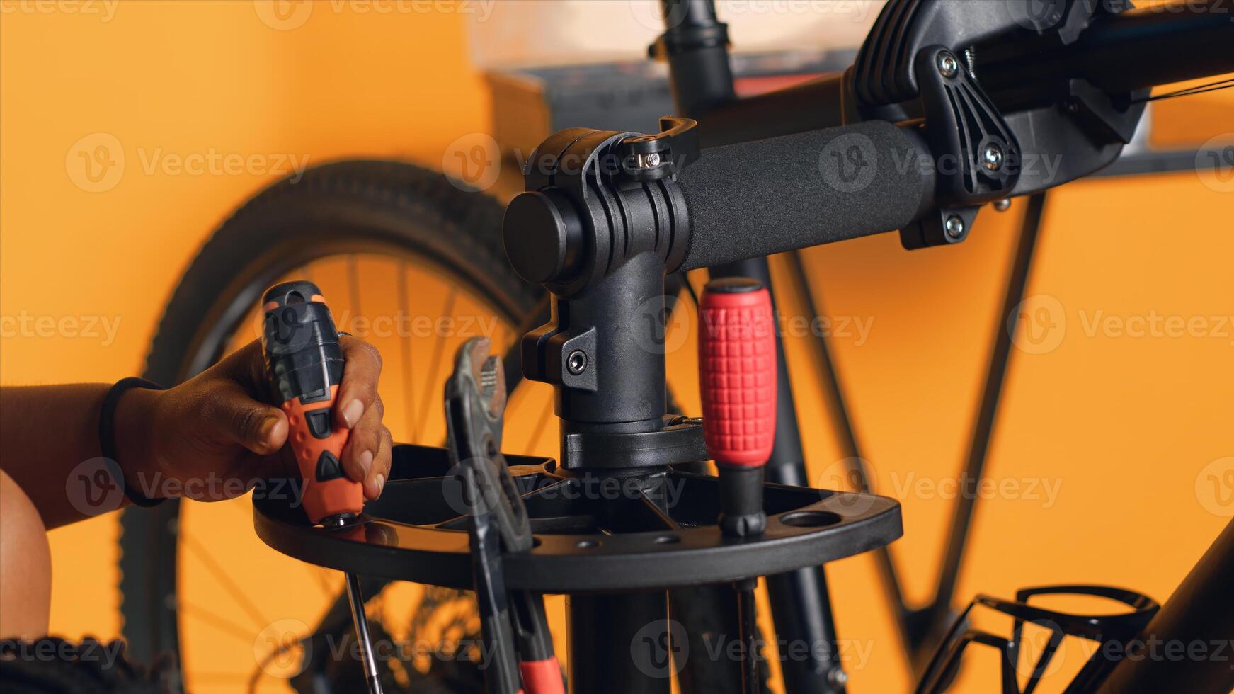 Close up shot of repairman preparing work tools before starting mending broken customer bicycle, studio background. Expert arranging mechanical gear, ready to start servicing bike, camera A photo