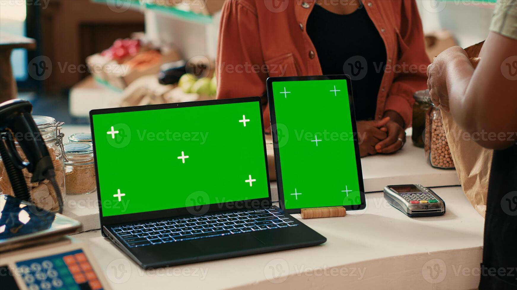 Laptop and tablet running greenscreen layout in local store, promoting sustainable lifestyle and zero waste farming. Vendor at checkout uses devices with chromakey display isolated mockup. photo