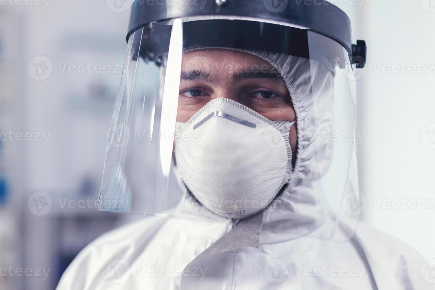 Close up of wearied chemist in laboratory wearing ppe equipment during mondial outbreak with covid19. Overworked researcher dressed in protective suit against invection with coronavirus during global epidemic. photo