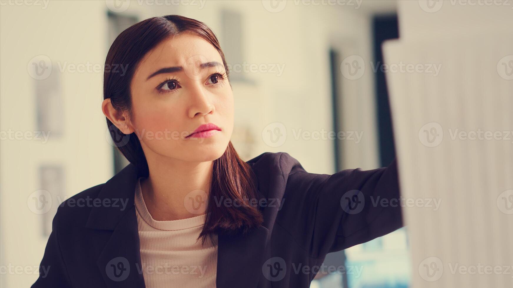 Asian architect examines industrial blueprints and maquette to calculate real measurements and lines dimension. Technician looking at 3D building model and analyzing layout sketch. Handheld shot. photo