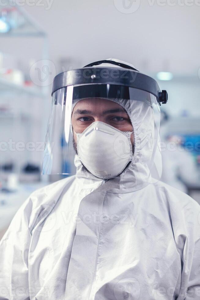 Overworked researcher dressed in protective suit against invection with coronavirus during global epidemic. photo