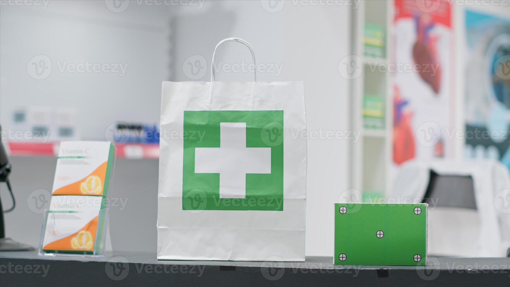 Empty pharmacy with pills and vitamins at cash register, paper bag containing pharmaceuticals alongside greenscreen layer on pill box at checkout area. Chromakey copyspace design next to purchase. photo