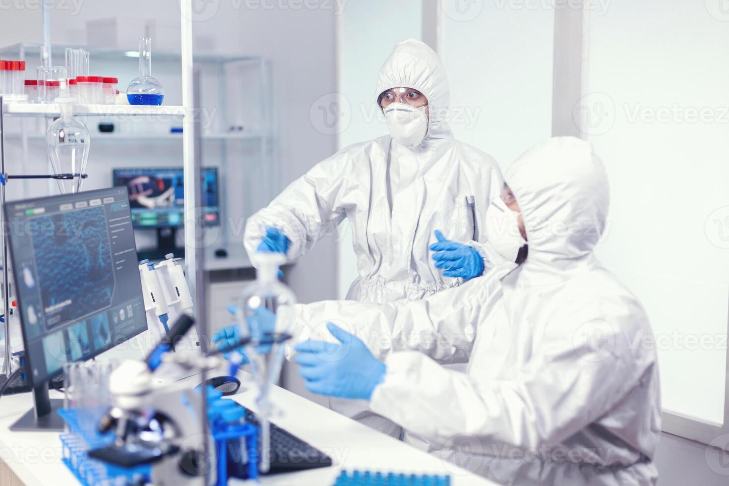 emocionado científicos después descubriendo coronavirus vacuna durante trabajo en moderno laboratorio. equipo de doctores trabajando con varios bacterias y tejido, farmacéutico investigación para antibióticos en contra COVID-19. foto