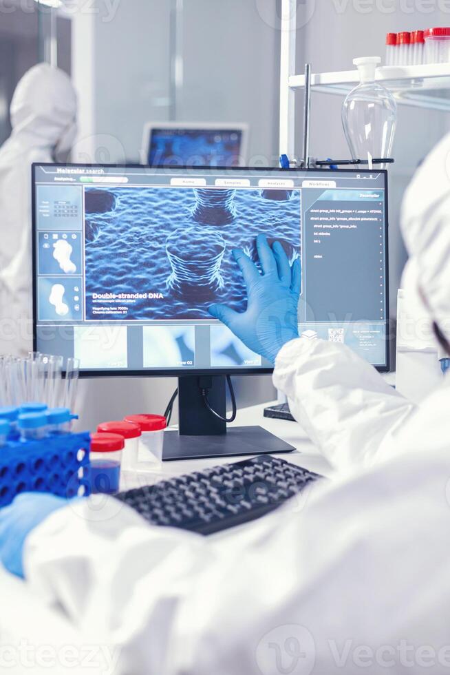 Chemist man looking computer screen working on vaccine against coronnavirus in modern facility. . Lab engineers conducting experiment for vaccine development against covid19 virus photo