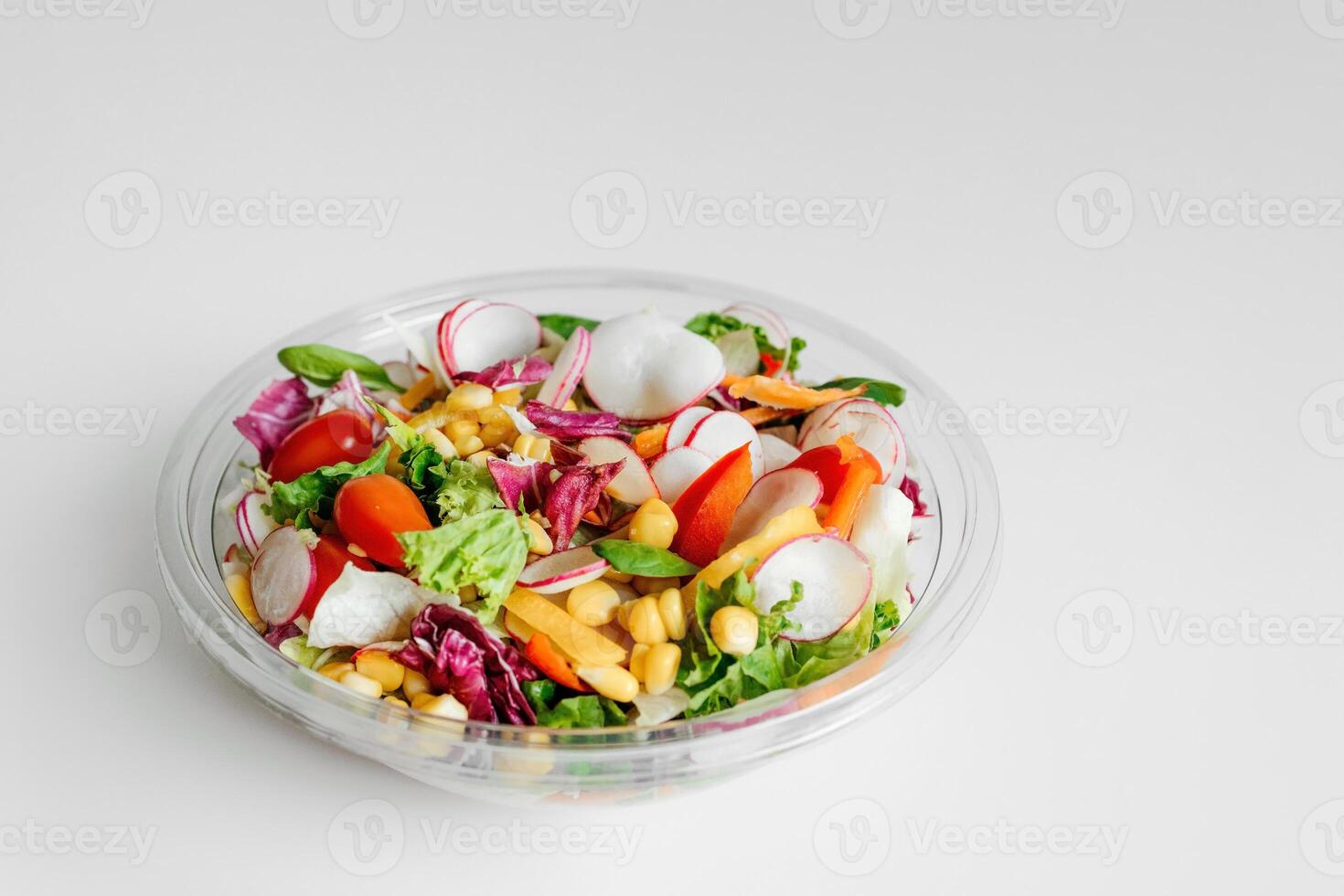 Salted vegan salad with fresh green lettuce, cucumbers, tomato, bell pepper and red onion. Ketogenic, keto or paleo diet lunch bowl. Top view. Copy space, banner, white background photo