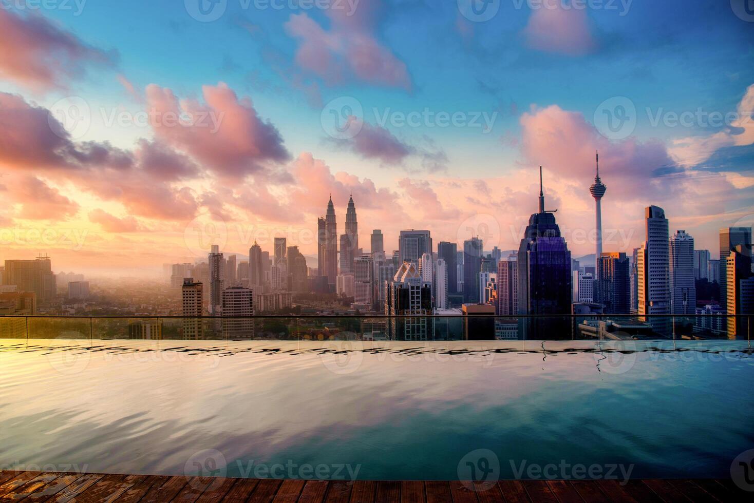 Cityscape of Kuala lumpur city skyline with swimming pool on the roof top of hotel at sunrise in Malaysia. photo