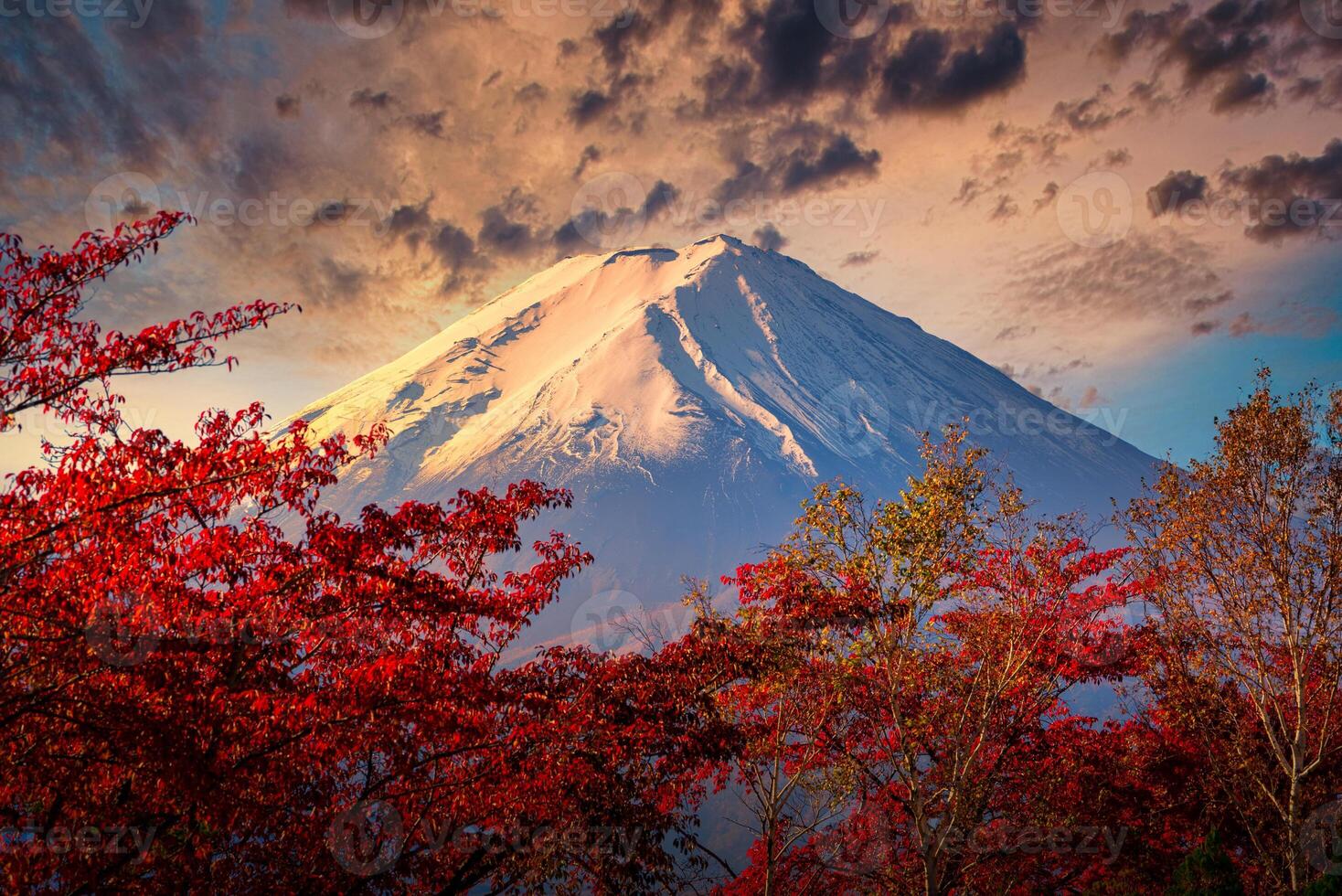 Mt. Fuji on dramatic sky with autumn foliage at sunset in Fujikawaguchiko, Japan. photo