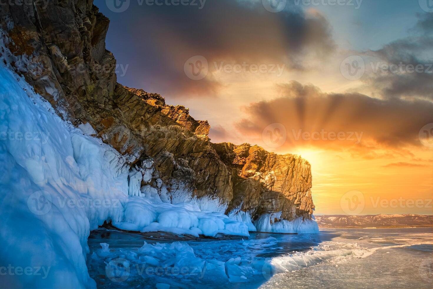 Landscape of Mountain at sunset with natural breaking ice in frozen water on Lake Baikal, Siberia, Russia. photo