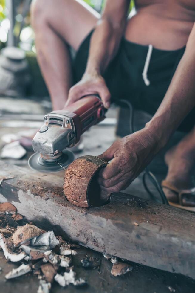 Using electric blades to sharpen coconut shells to be smooth. photo