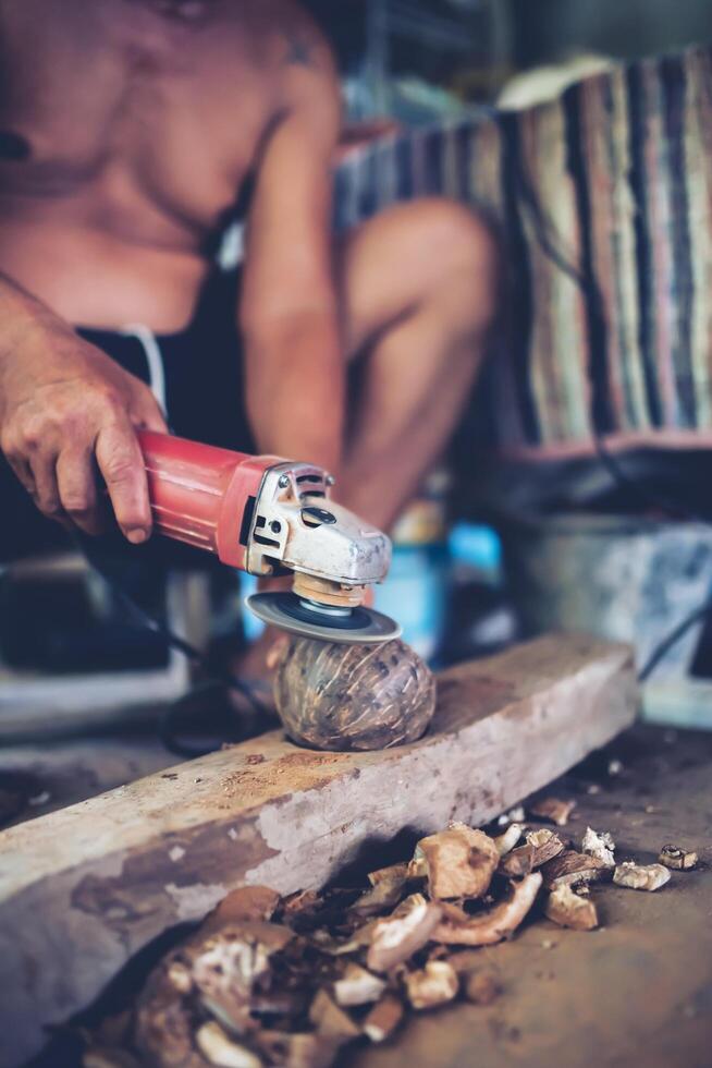 Using electric blades to sharpen coconut shells to be smooth. photo