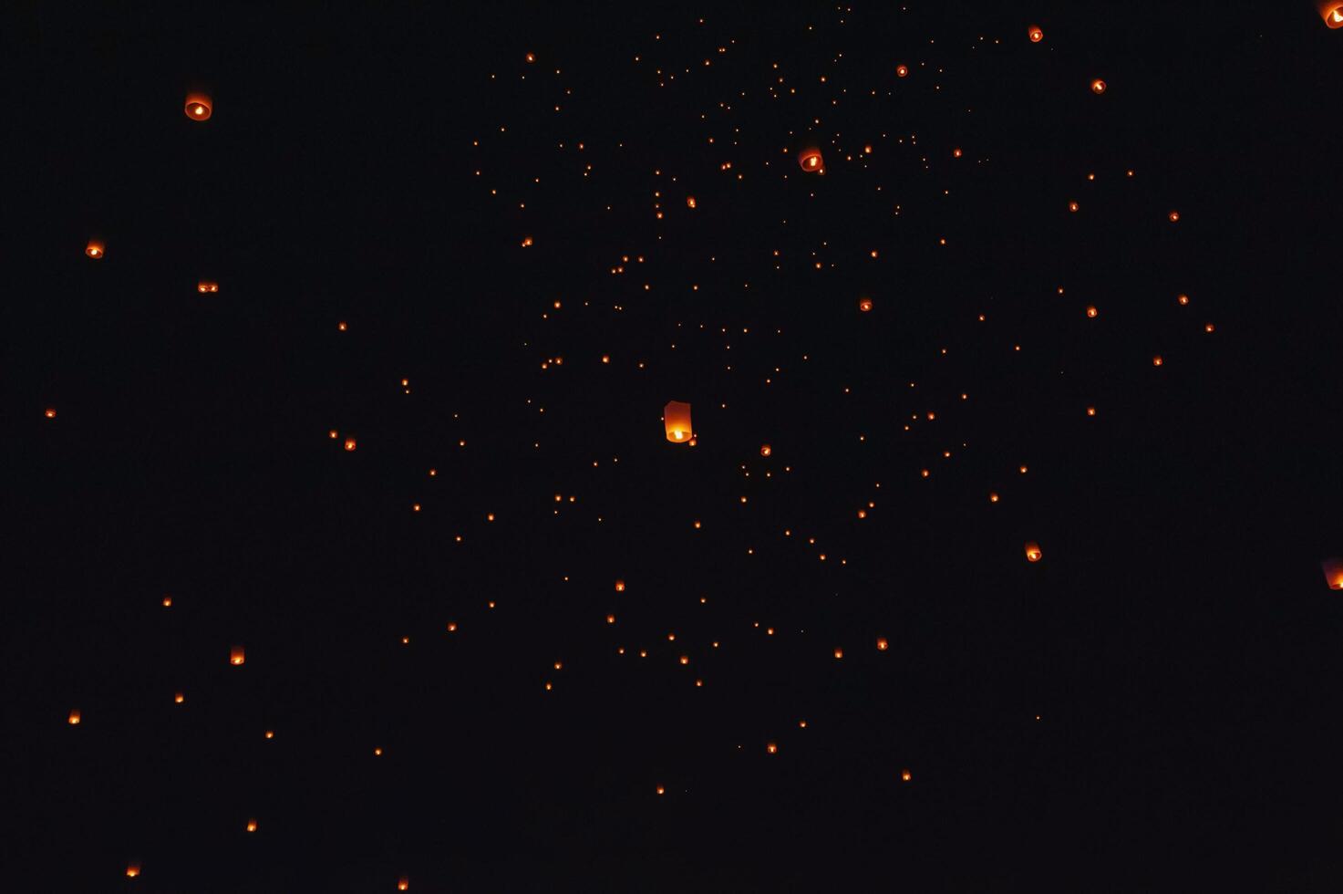 The beauty of the lanterns floating in the sky during the Yi Peng Festival and the Floating Lantern Festival in Chiang Mai Province, Thailand. photo