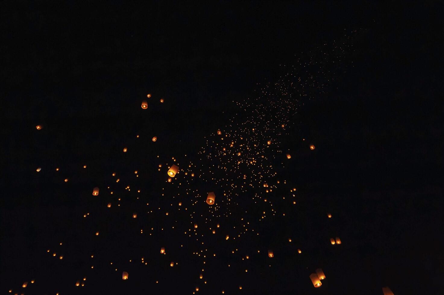 The beauty of the lanterns floating in the sky during the Yi Peng Festival and the Floating Lantern Festival in Chiang Mai Province, Thailand. photo