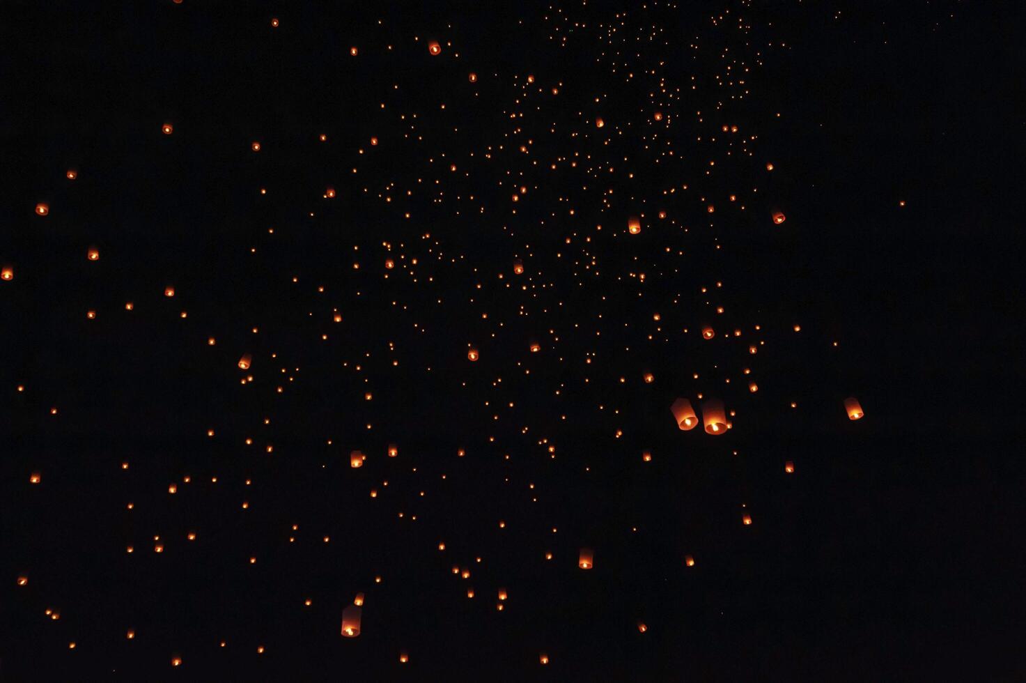 The beauty of the lanterns floating in the sky during the Yi Peng Festival and the Floating Lantern Festival in Chiang Mai Province, Thailand. photo