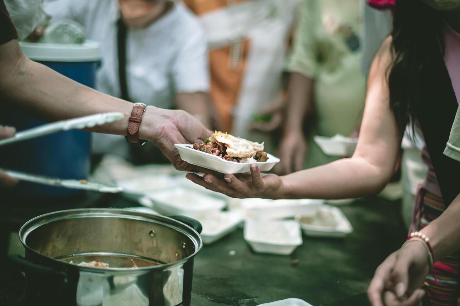 Feeding concept Homeless people offer free food from outdoor volunteers. photo