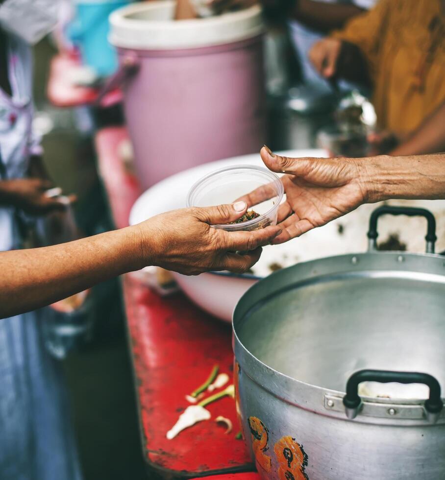 Volunteers distribute simple meals to the poor at the free food kitchen. photo