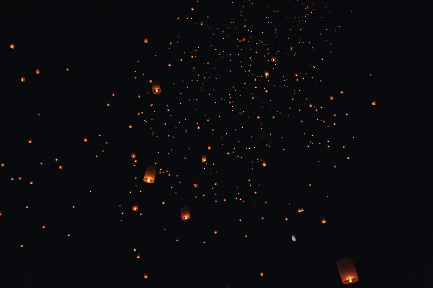 The beauty of the lanterns floating in the sky during the Yi Peng Festival and the Floating Lantern Festival in Chiang Mai Province, Thailand. photo