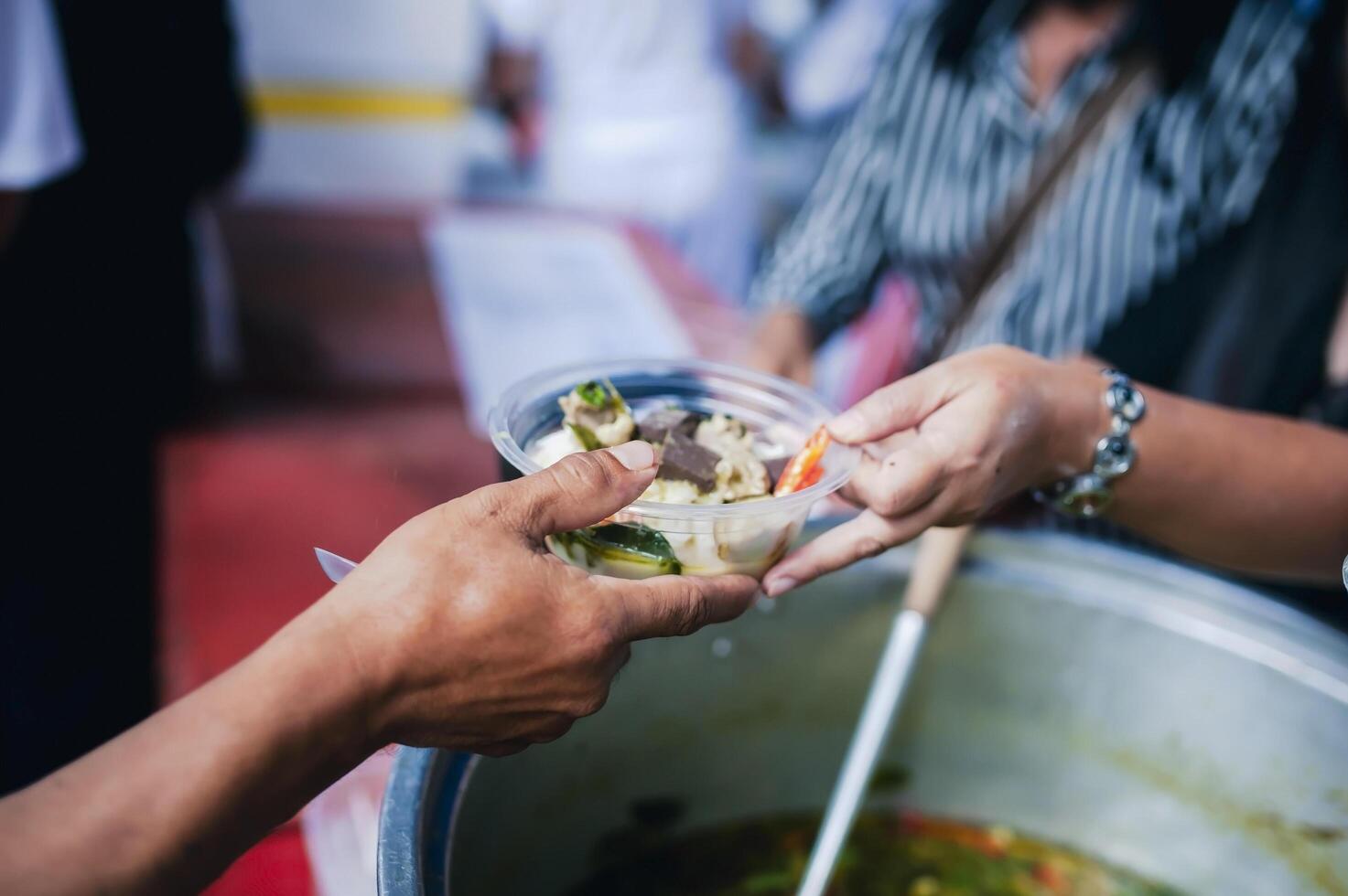 concept of charity food for the poor . the concept of life problems, hunger in society . Helping People With Hunger With Kindness. The hands of beggars receive donated food photo