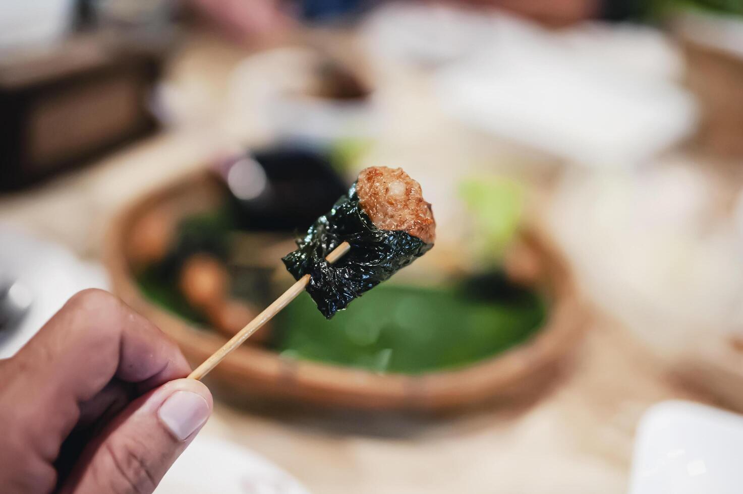 Pork skewers wrapped in fried betel leaves make a delicious appetizer. photo