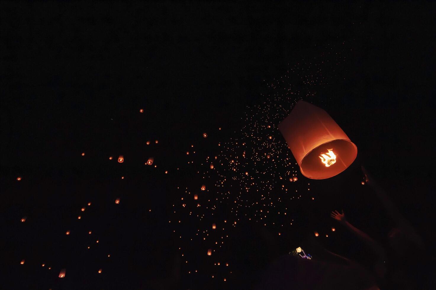 The beauty of the lanterns floating in the sky during the Yi Peng Festival and the Floating Lantern Festival in Chiang Mai Province, Thailand. photo