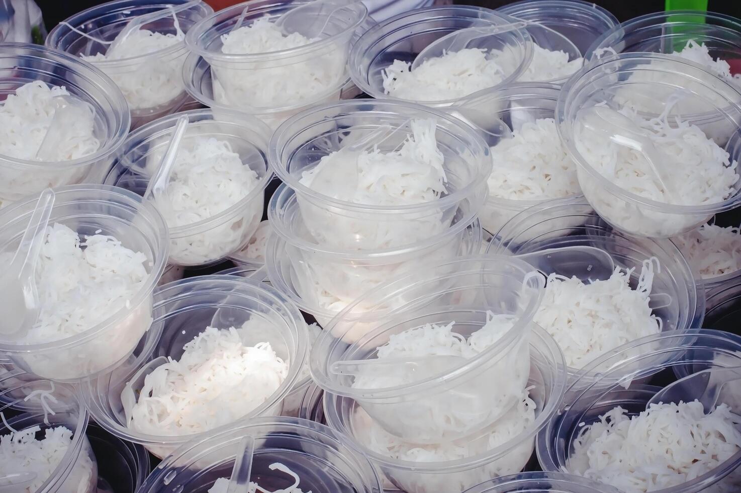 Food noodles come in clear plastic cups stacked for free food distribution. photo