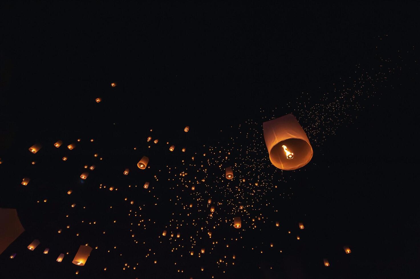 The beauty of the lanterns floating in the sky during the Yi Peng Festival and the Floating Lantern Festival in Chiang Mai Province, Thailand. photo