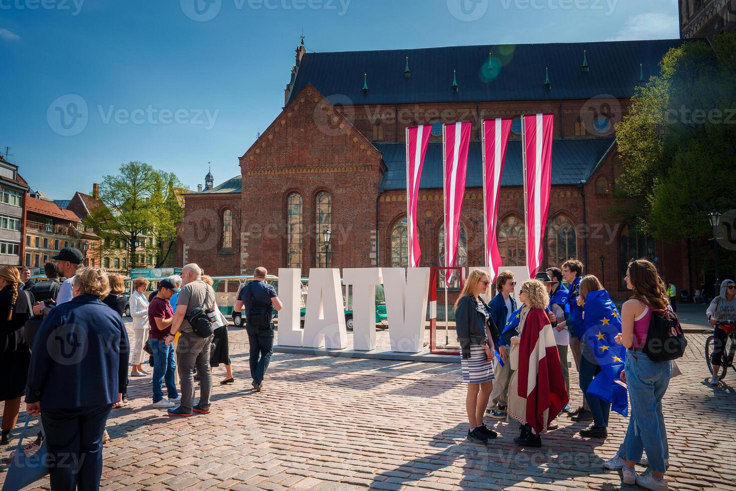 Crowd in Old Town Riga Celebrates Latvia EU Union, Sunny Day photo