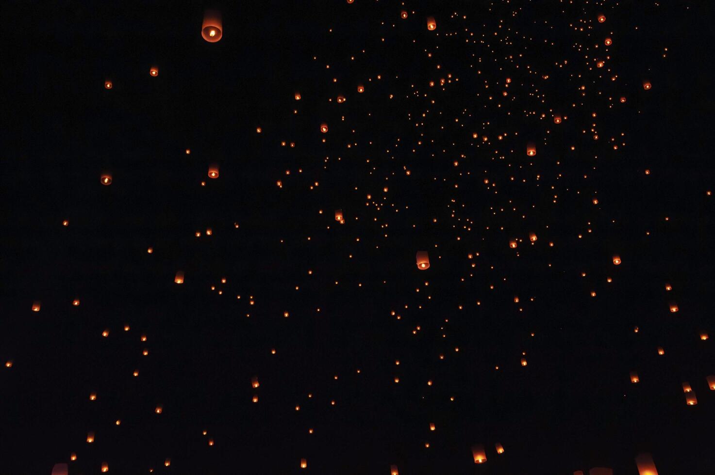 The beauty of the lanterns floating in the sky during the Yi Peng Festival and the Floating Lantern Festival in Chiang Mai Province, Thailand. photo