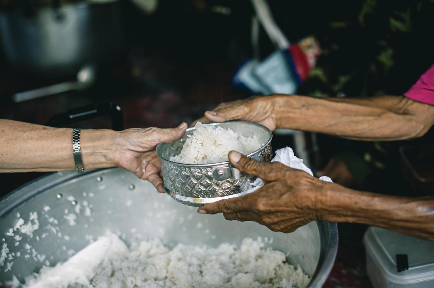 concept of charity food for the poor . the concept of life problems, hunger in society . Helping People With Hunger With Kindness. The hands of beggars receive donated food photo