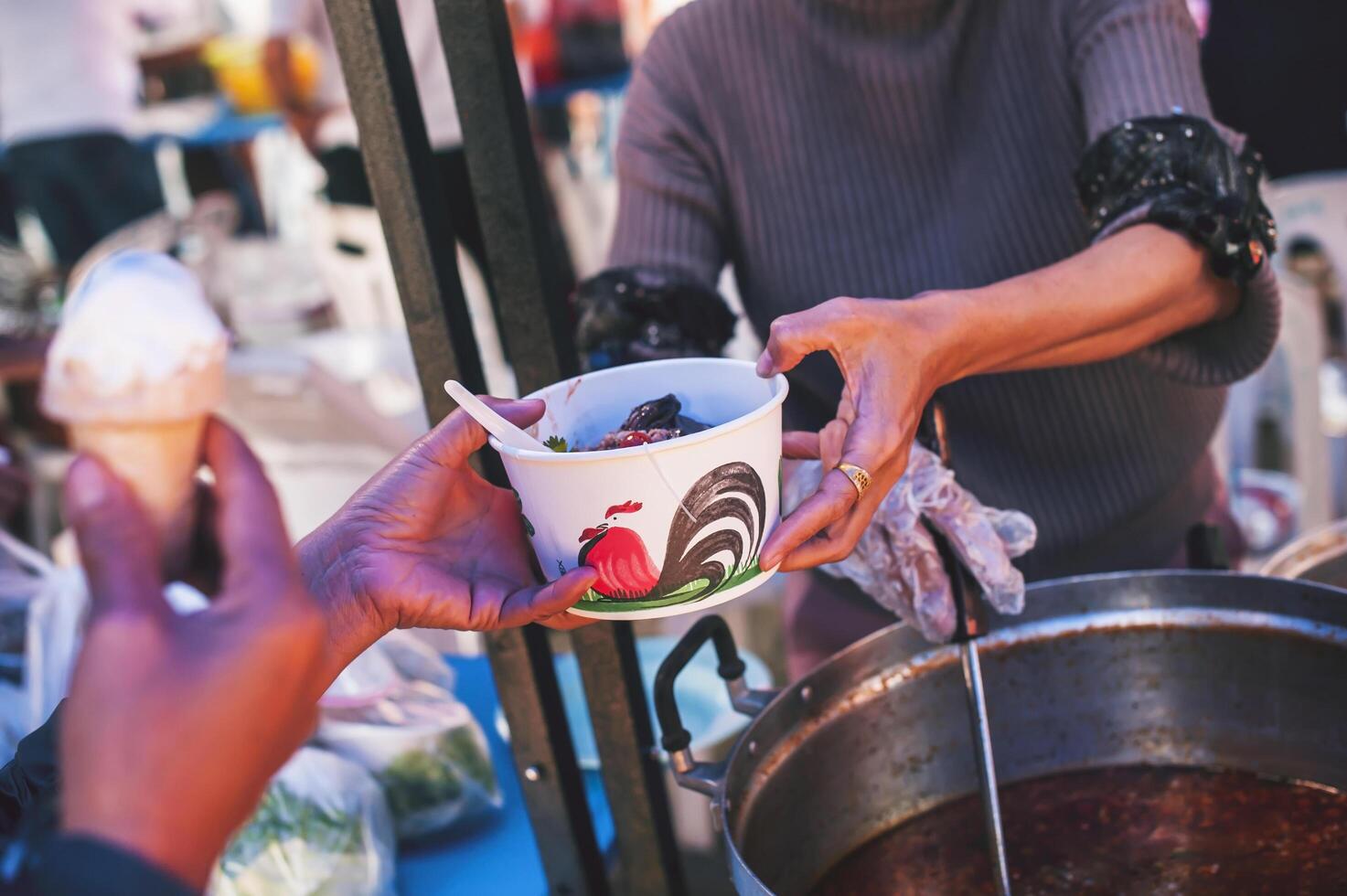 Volunteers serving hot meals to hungry migrants humanitarian aid concept. photo