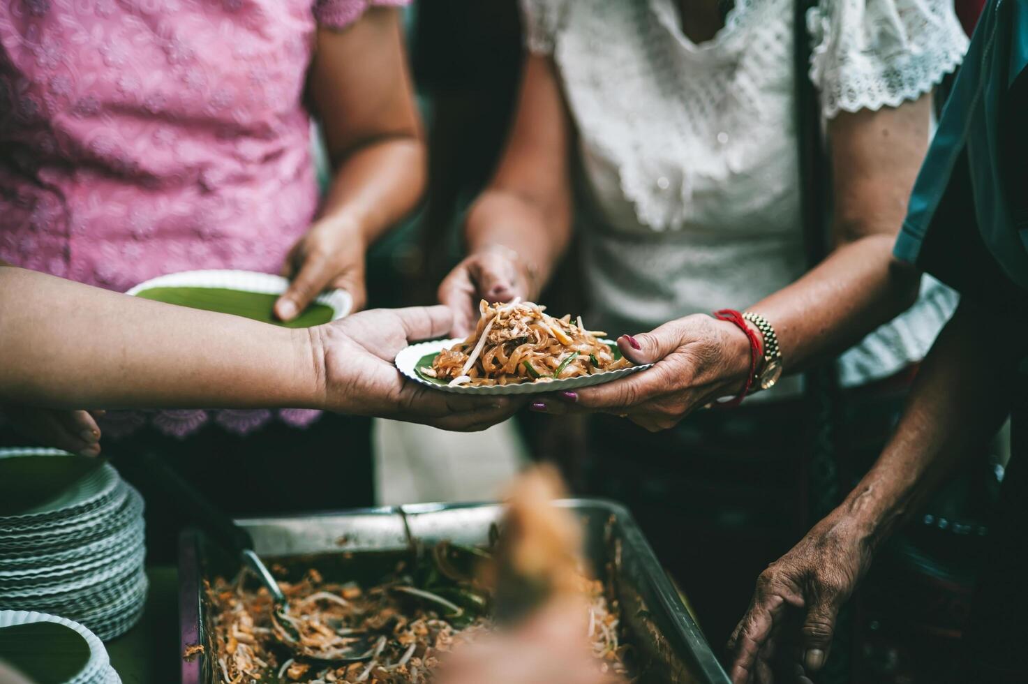 Volunteers are giving free food to help the hungry poor concept of food sharing photo
