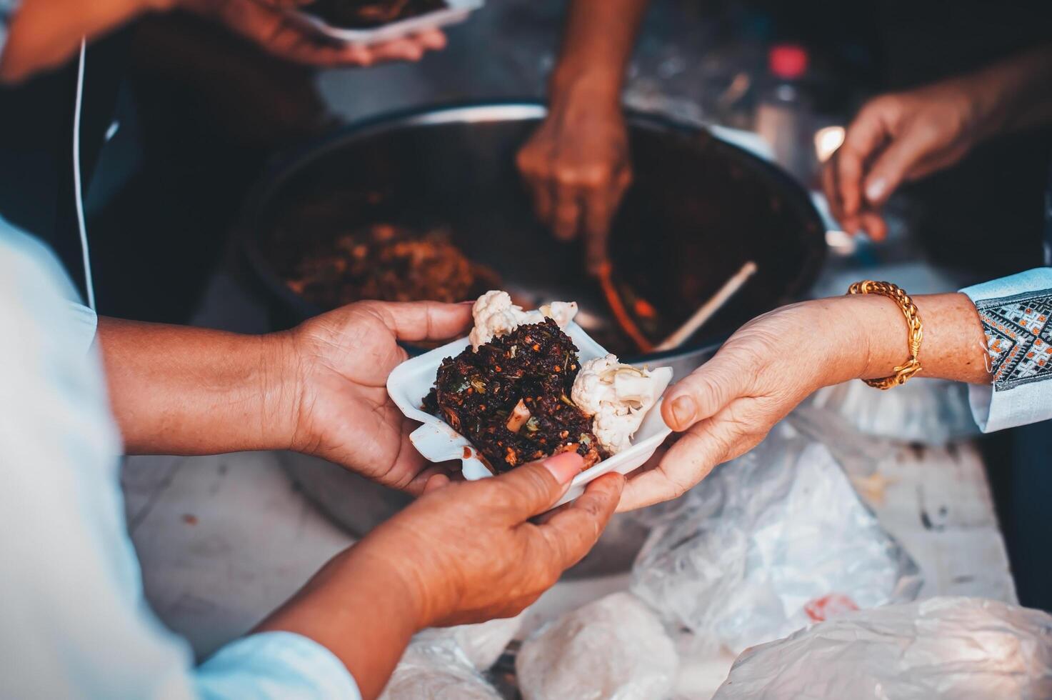 Volunteers serving hot meals to hungry migrants humanitarian aid concept. photo