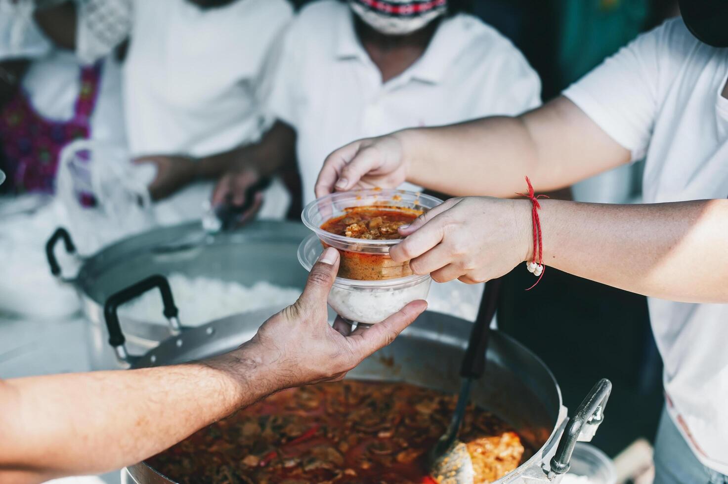 Volunteers serving hot meals to hungry migrants humanitarian aid concept. photo