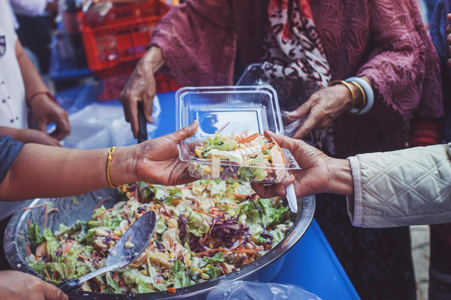 volunteer serving food to the homeless in the Community Charitable Donation Center Concept of free food assistance service photo